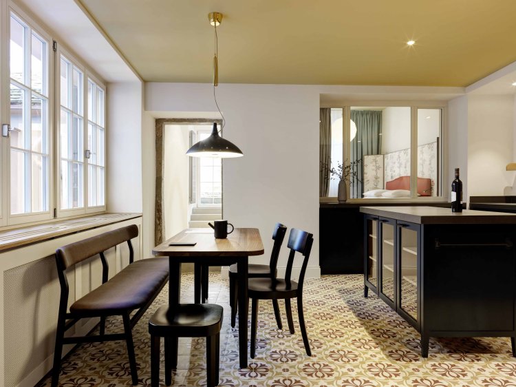 Modern ausgestaltete Küche und gemusterter Kachelboden in einer der Apartmentwohnungen des Hotel Widders in Zürich.