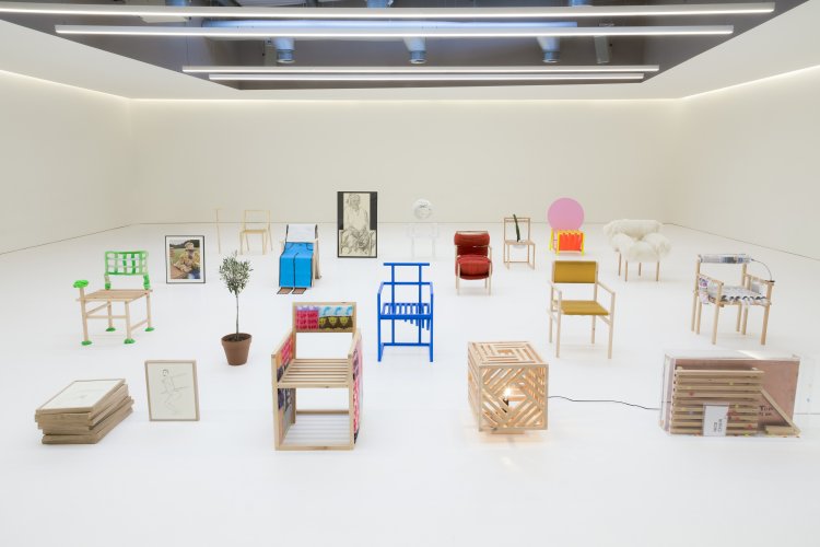 Die 19 bunten und unterschiedlichen Stuhlentwürfe von 19 verschiedenen Designern und Künstlern aus dem Projekt 19 Chairs sind in einer grossen weissen Galerie ausgestellt.