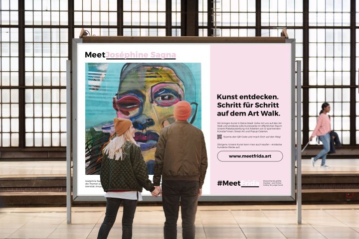 Zwei Passanten stehen vor einer Plakatwand an einer Bahnstation und betrachten ein Plakat der Online-Galerie "MeetFrida".
