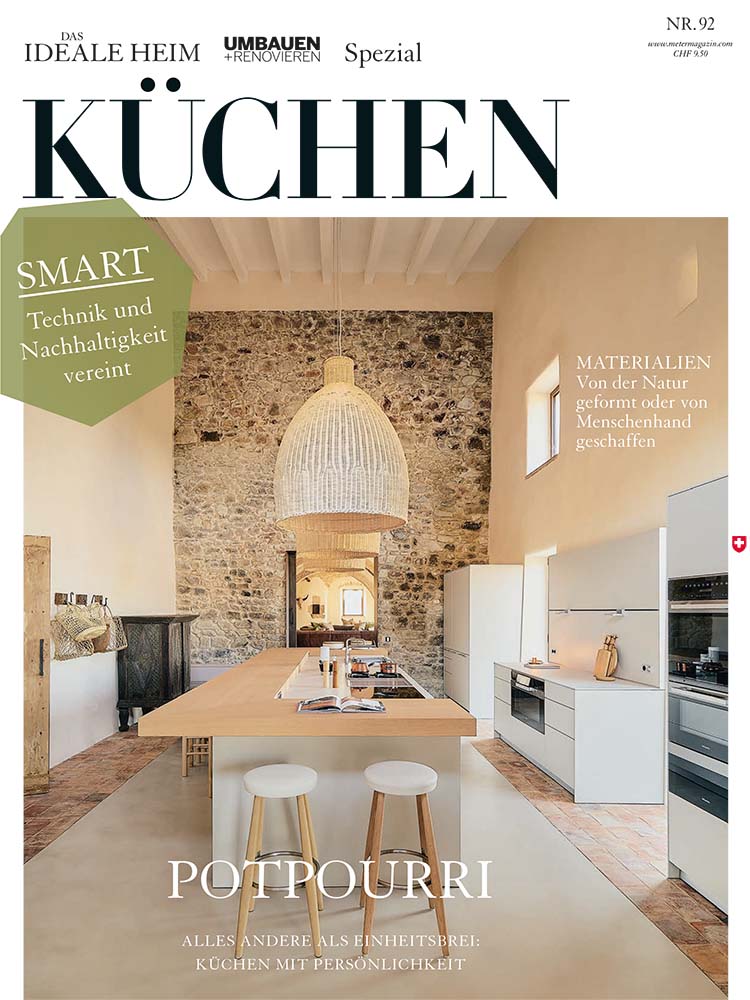 Das Cover der Jahresspezialpublikation Küchen zeigt eine offene, helle Wohn- und Essküche vor einer Rückwand aus freigelegten Steinen.