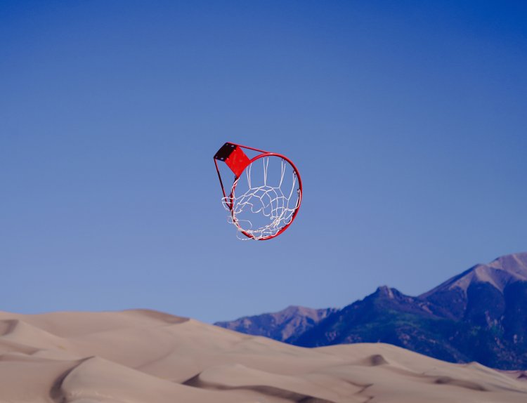 Eine Fotoaufnahme von Douglas McCurdy eines durch die Luft fliegenden Basketballkorbs in einer Wüstenlandschaft.