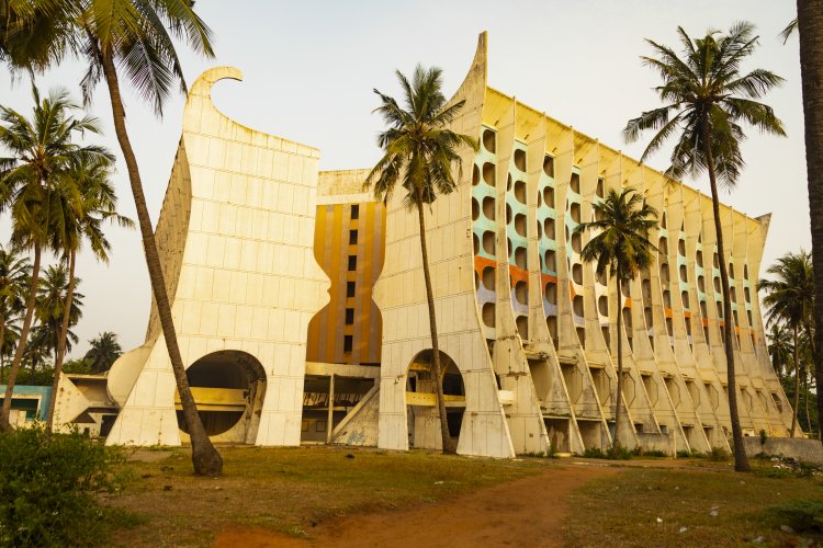 Aussenaufnahme des etwas verfallenen, leerstehenden Hotel de la Paix in Lomé, Togo in goldenem Licht.