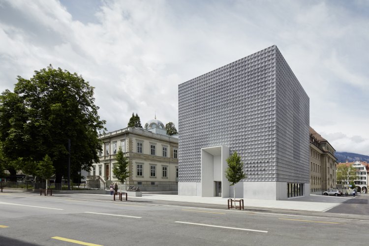 Aussenansicht eines modernen Betonkubus mit einem Raster aus kassettierten Elementen.
