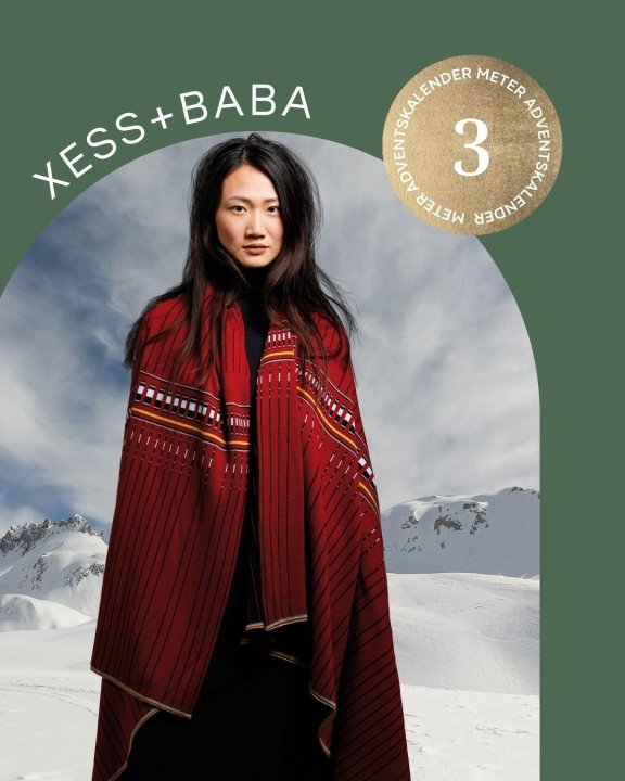 Frau mit umgelegter Wolldecke vor Bergkulisse