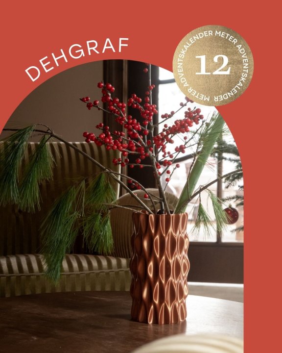 Vase mit weihnachtlichen Zweigen auf Tisch