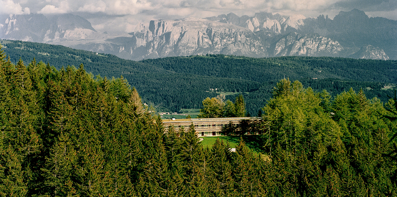 Mountain resort umgeben von Wäldern mit Bergen und wolkigem Himmel im Hintergrund