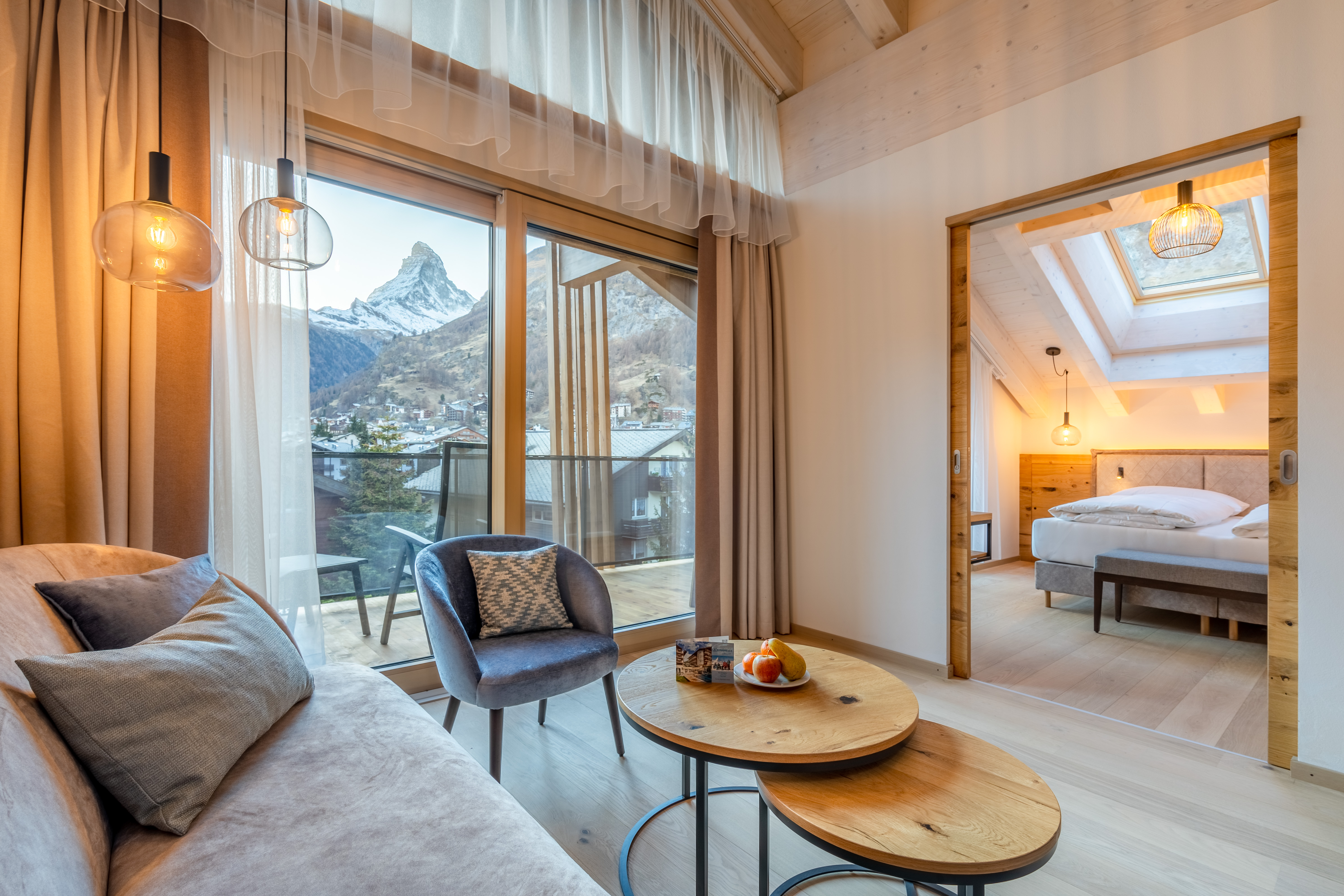 Modern eingerichtetes Hotelzimmer mit Dachbalken mit Blick auf das Matterhorn