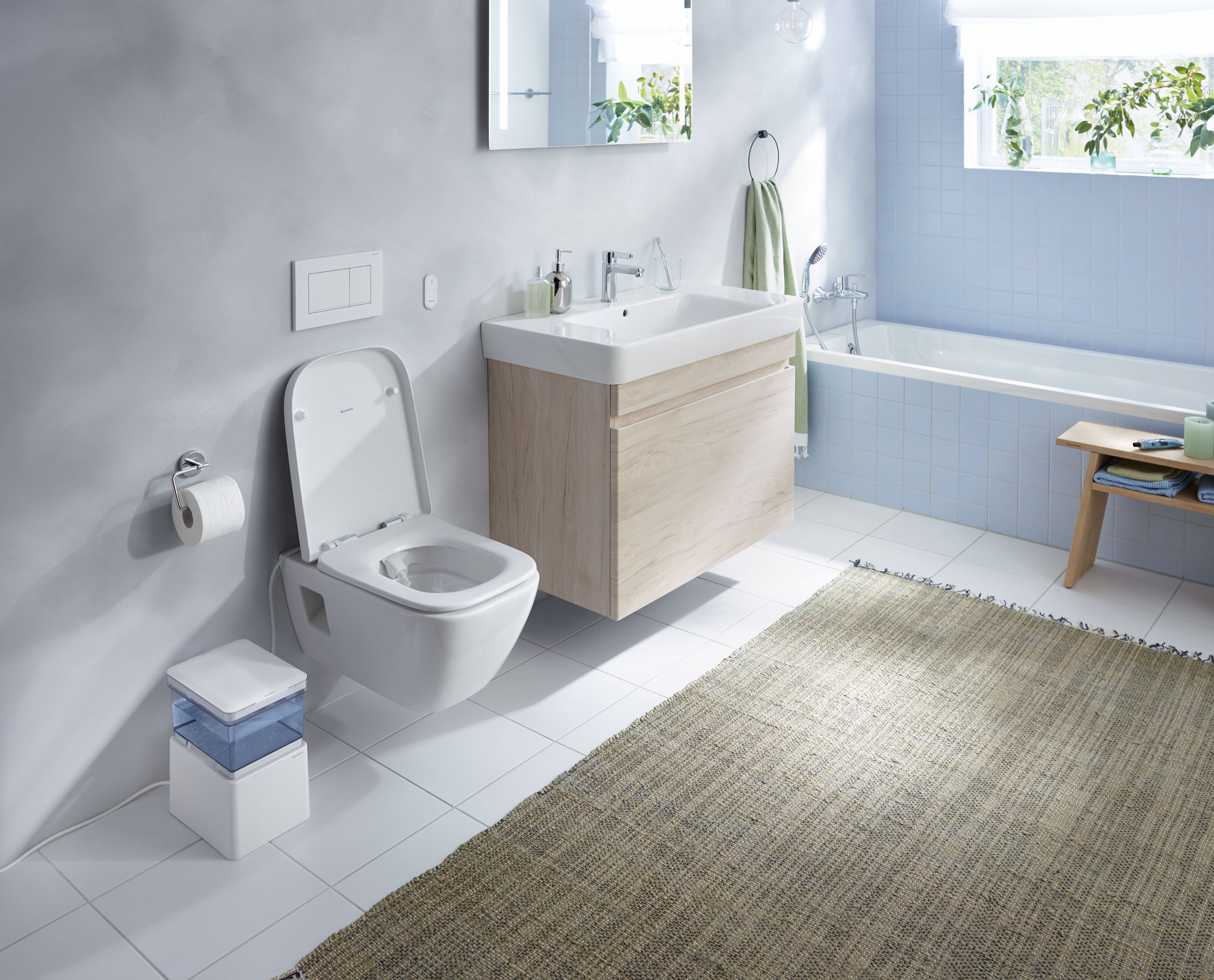 Geberit AquaClean Cama Dusch-WC in blau-grauem Bad mit Rattanteppich