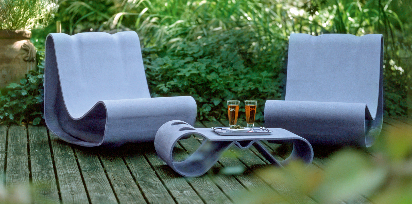 Zwei Guhl-Stühle auf einem Holzdeck mit passendem Beistelltisch mit zwei Gläsern darauf